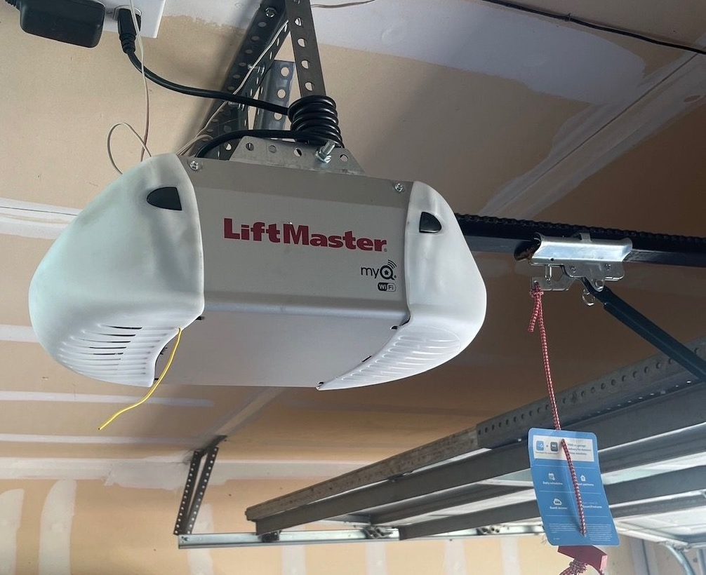 A LiftMaster garage door opener with battery backup. The unit is mounted to a metal frame.