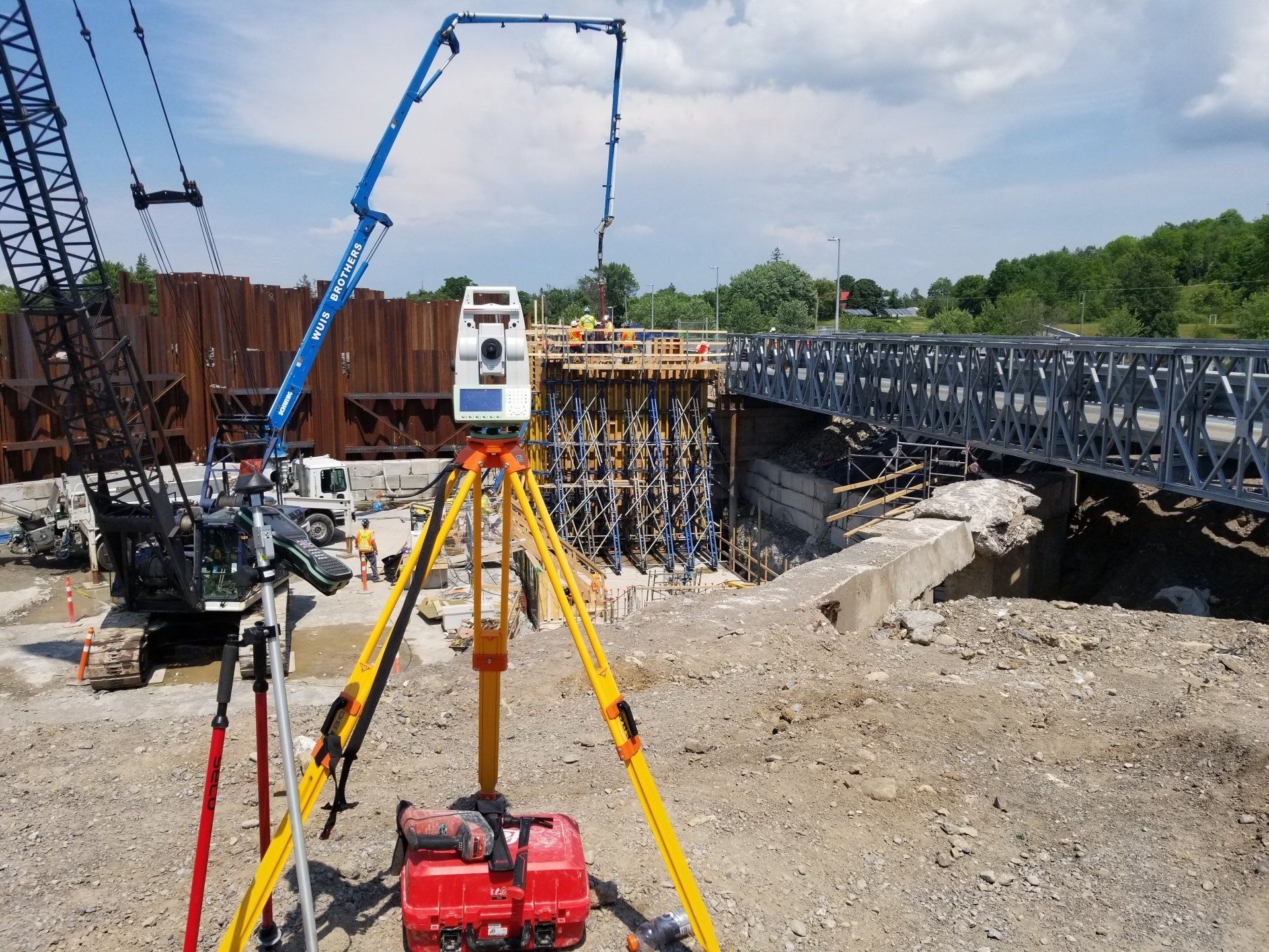 A construction site with a crane and a camera on a tripod