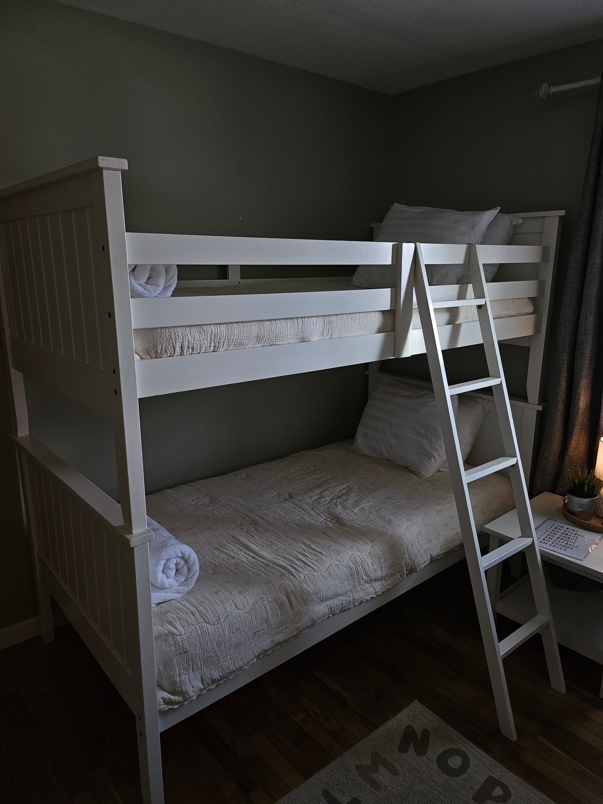 A bunk bed with two beds and a ladder in a bedroom.