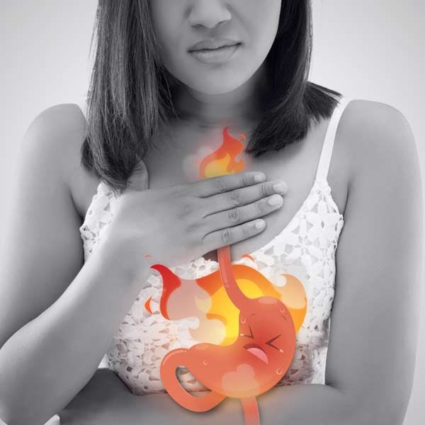 A woman is holding her chest with her hand, and her stomach is visible. Overcome Chronic and Severe Acid Reflux Using Holistic and Integrative Approaches for Long-term Relief by Salerno Wellness in Manhattan, NY, and Connecticut