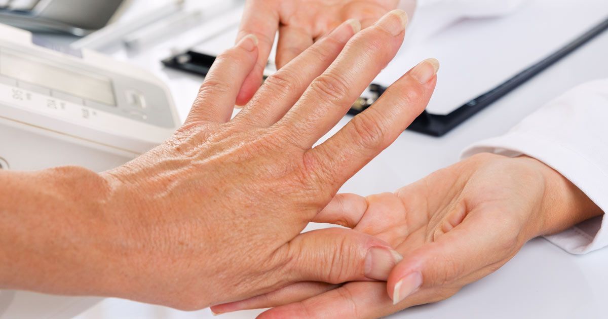 A close-up of a person 's hand being examined by a doctor for Arthritis Treatments NYC