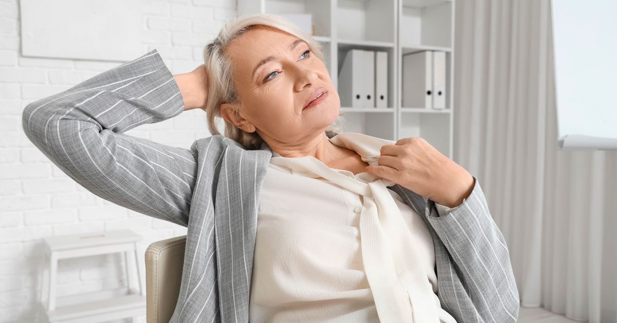 A woman at work with hot flashes needing Bioidentical Hormone Replacement Therapy NYC 