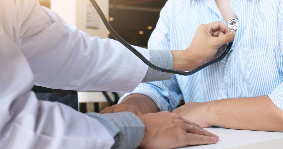 Complementary Medicine Doctor NYC using a stethoscope to listen to a patient's heart during a checkup.