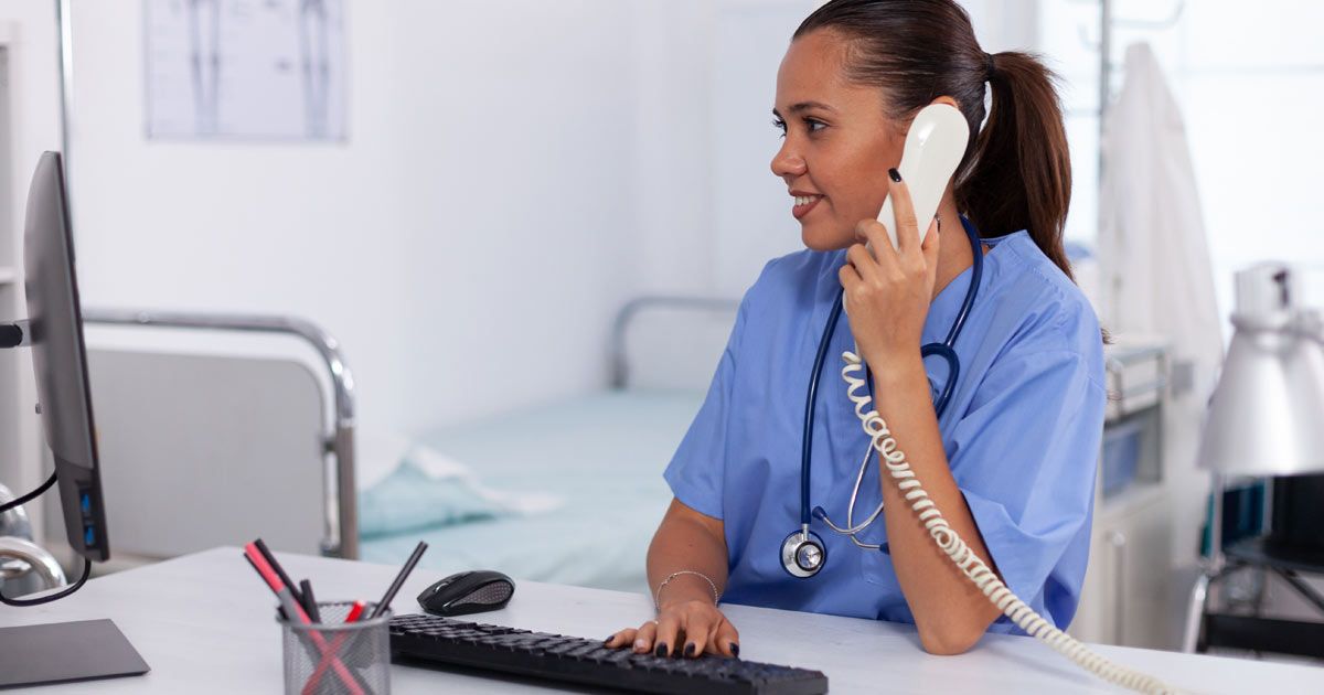 A nurse is sitting at a desk talking on a phone while using a computer Contact Dr John Salerno