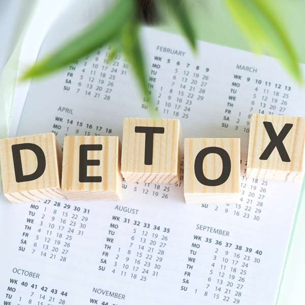 The word detox is written in wooden blocks on top of a calendar representing Detoxification IV Treatments