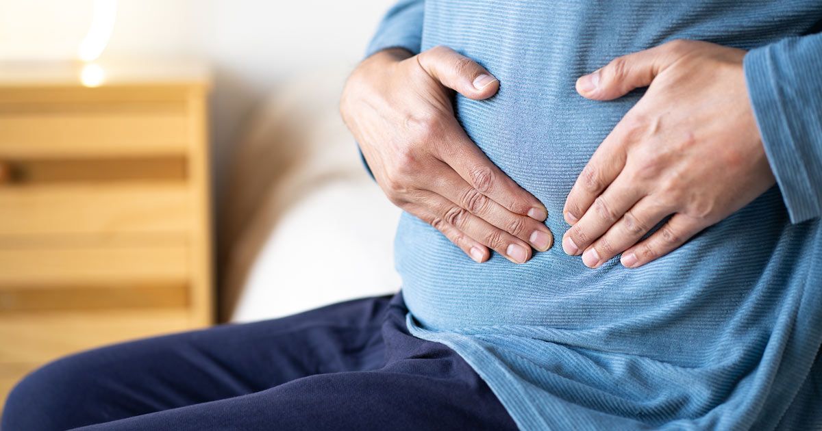 A man holding his stomach in pain needing Diverticulosis Treatments NYC by Dr. John Salerno