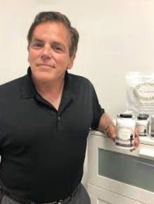 Dr John Salerno Picture with Supplements He Developed from Over Thirty Years of Medical Care Experience