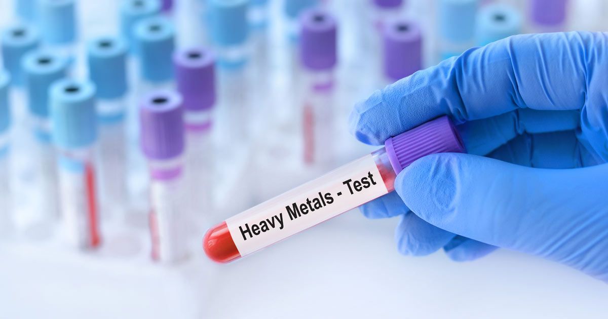 A person is holding a test tube with heavy metals written on it representing Heavy Metal Detoxification NYC by Dr. John Salerno