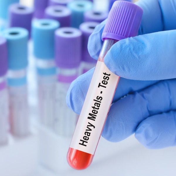 A person is holding a test tube that says heavy metals test for Heavy Metal Challenge Test