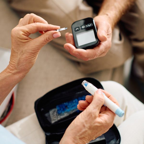 A diabetic testing their blood sugar, practicing Diabetes Management
