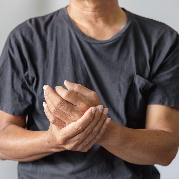 A man in a gray shirt is holding his hands together representing a need for MTHFR Treatments