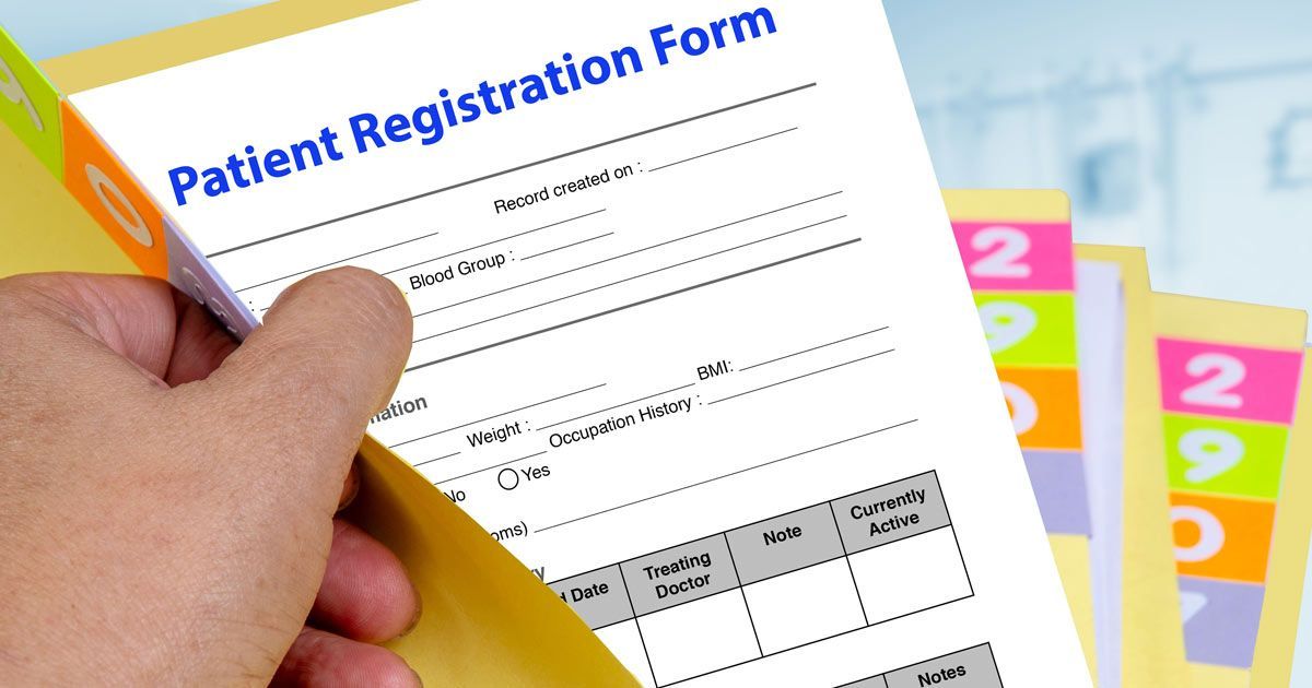 A person is holding a patient registration form in their hand, representing Patient Forms for Dr. John Salerno