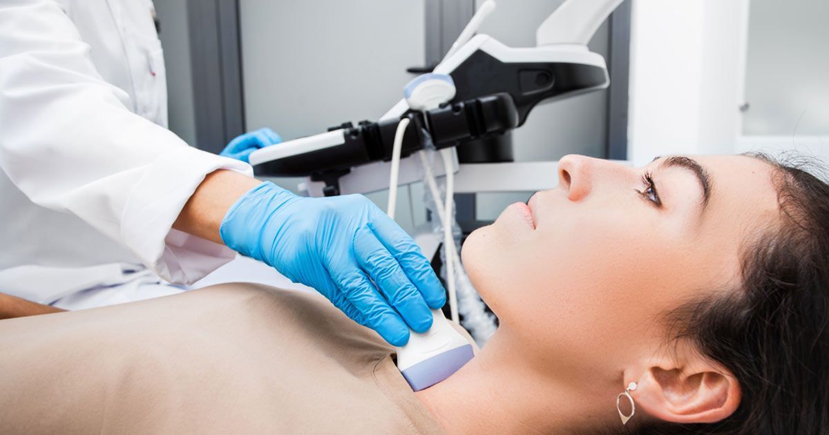 A woman is getting an ultrasound of her neck by a doctor for Thyroid Nodule Treatments NYC by Dr. John Salerno