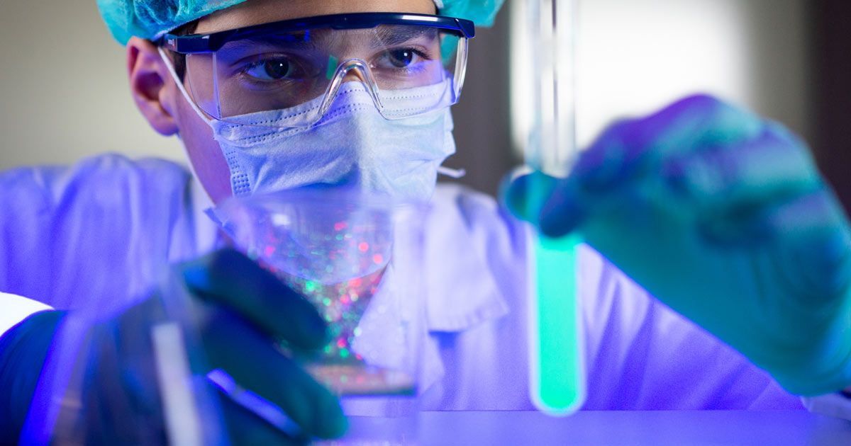 A doctor is pouring ultraviolet liquid into a test tube in a lab. Ultraviolet Blood Irradiation Therapy NYC - Dr. John Salerno.