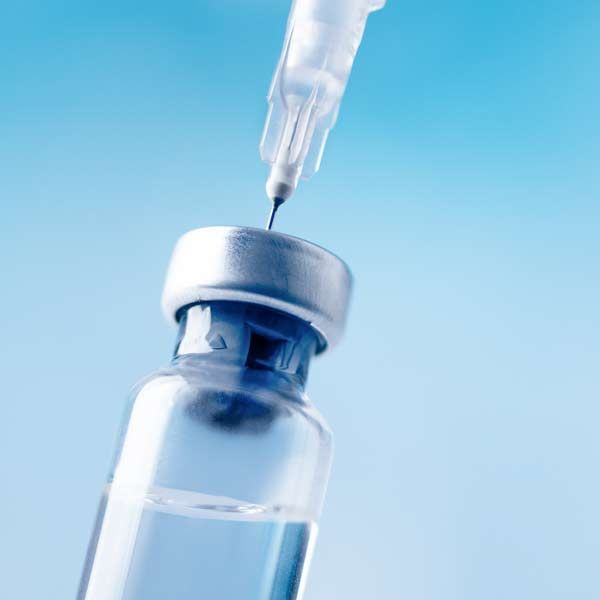 A syringe is being inserted into a bottle of GLP-1 Injections for Weight Loss