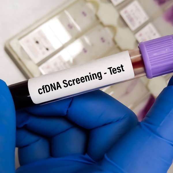 Gloved hand holding a blood sample vial labeled