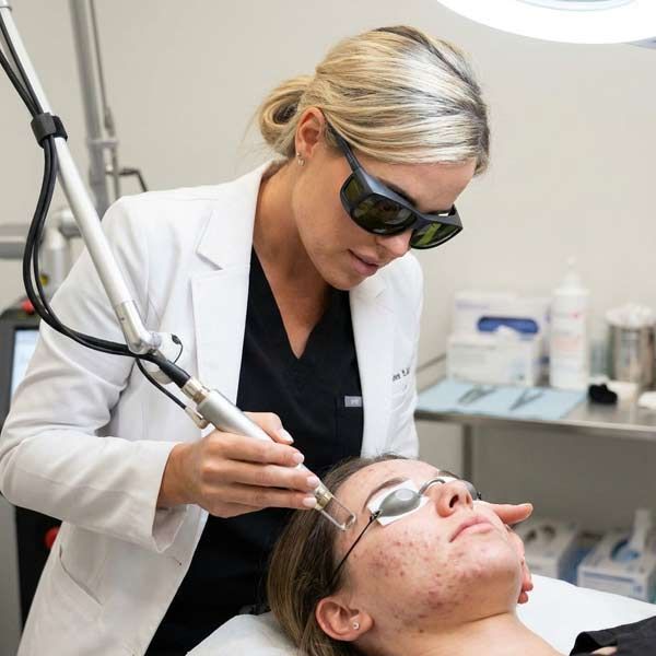 Helene Salerno performing a laser skin rejuvenation treatment on a patient's face at Salerno Wellness in NYC