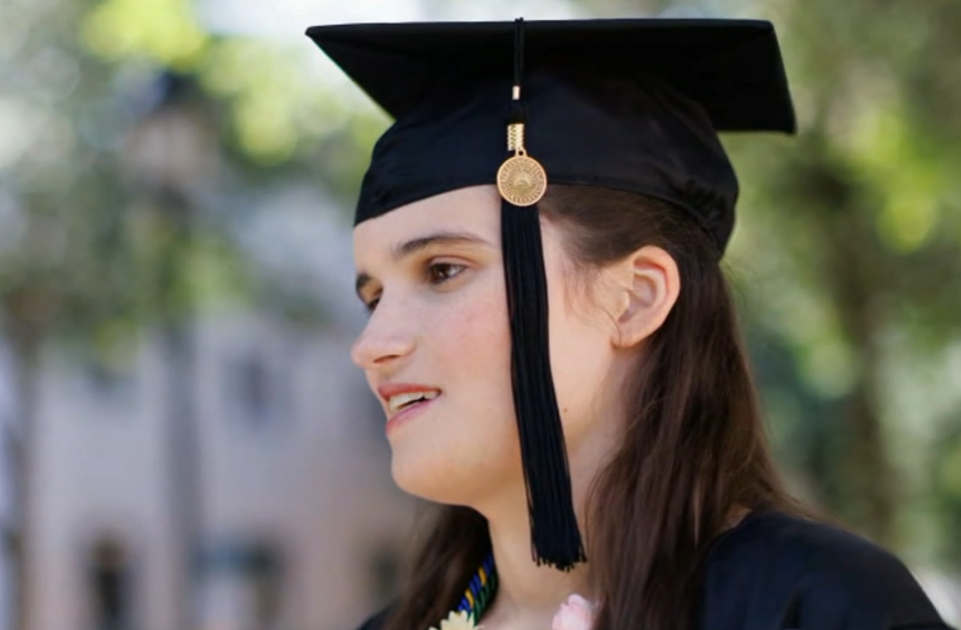 head shot of a lady wearing a graduation cap in black