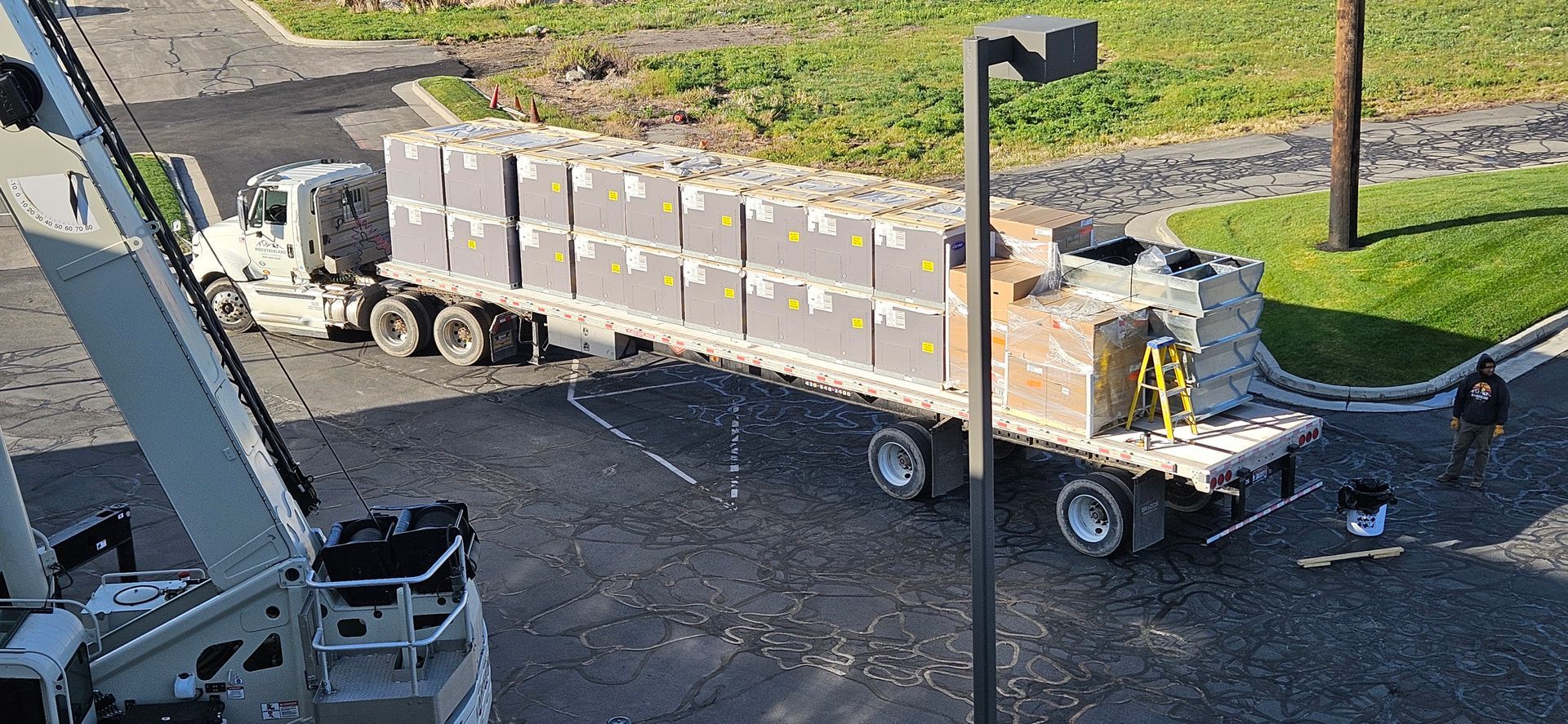 A truck is being loaded with boxes on a flatbed trailer.