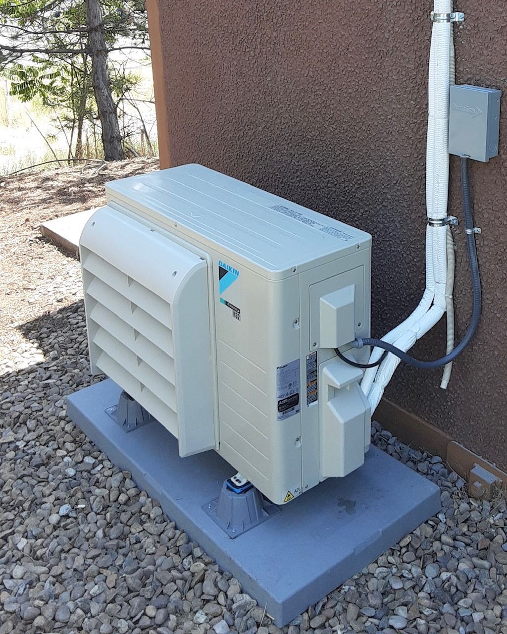 An air conditioner is attached to the side of a building