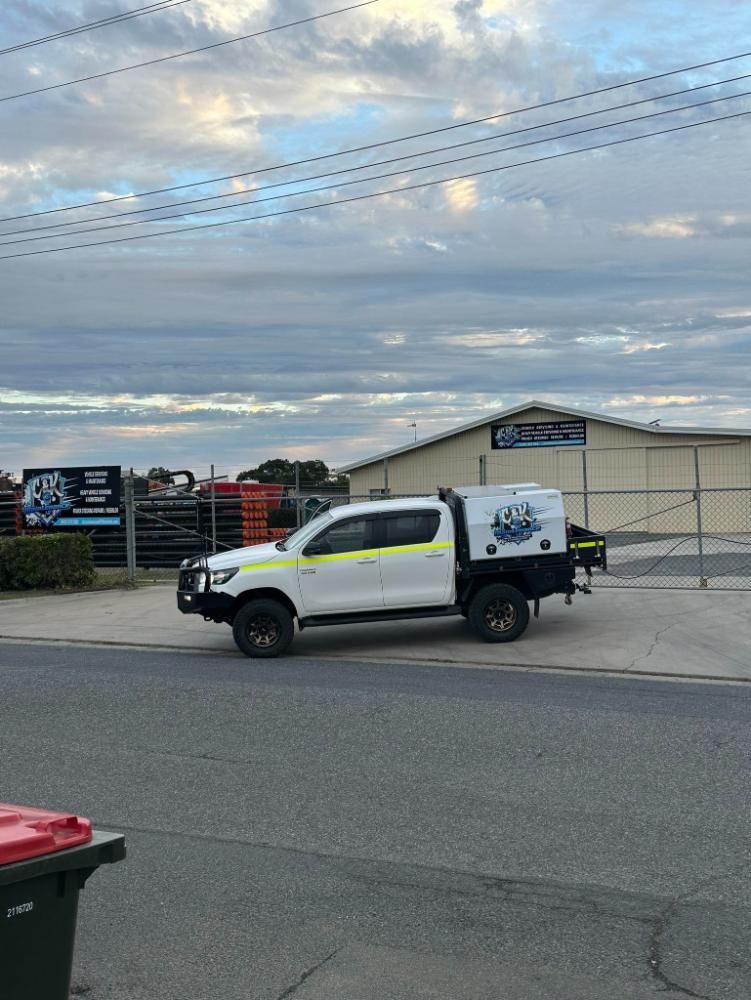 A White Truck Is Parked On The Side Of The Road In Front Of A Building — C & K Maintenance In Kawana, QLD
