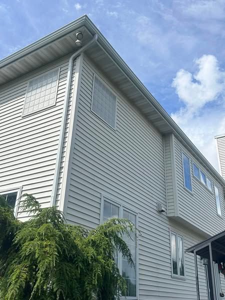 A large white house with a lot of windows and a blue sky in the background.