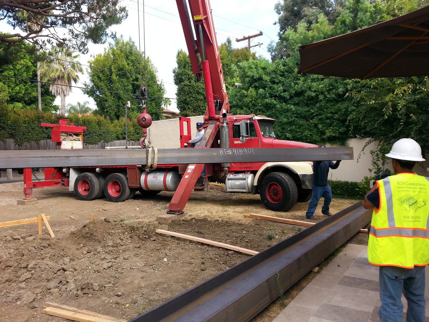 steel i beam unloaded from truck under oak tree— Los Angeles, CA — RCW Construction Inc.