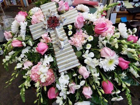 Cheap Flowers — Pink Roses With Cross In Middle Arrangement For Funeral in Ridgeland, MS