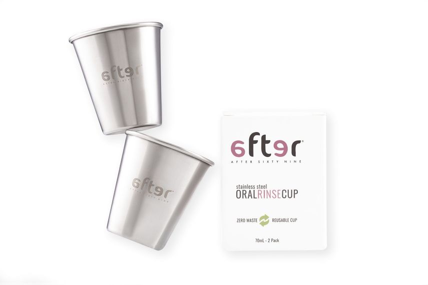 Two stainless steel cups and a card on a white background.