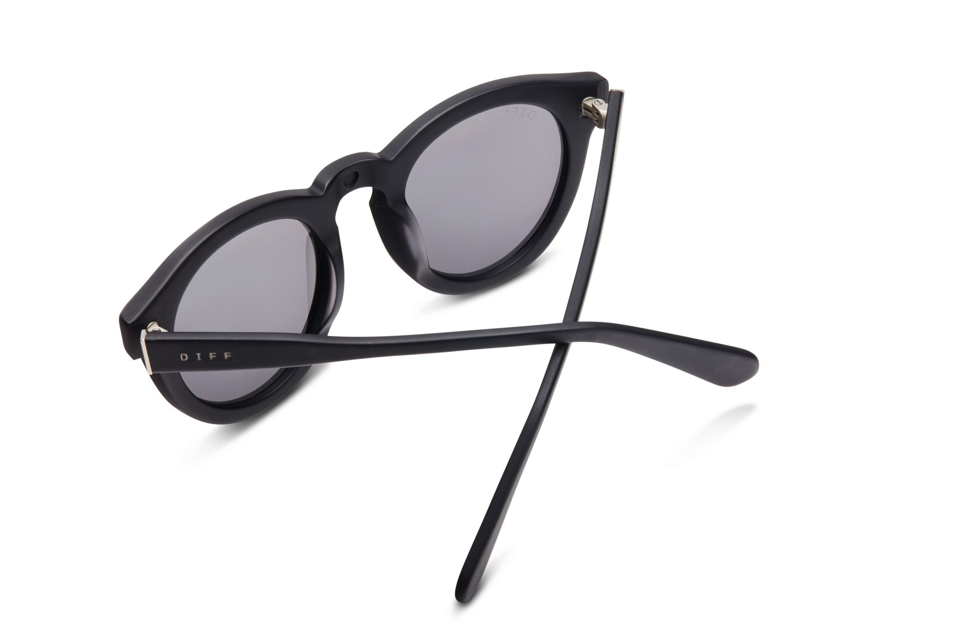 A pair of black sunglasses are laying on a white surface.