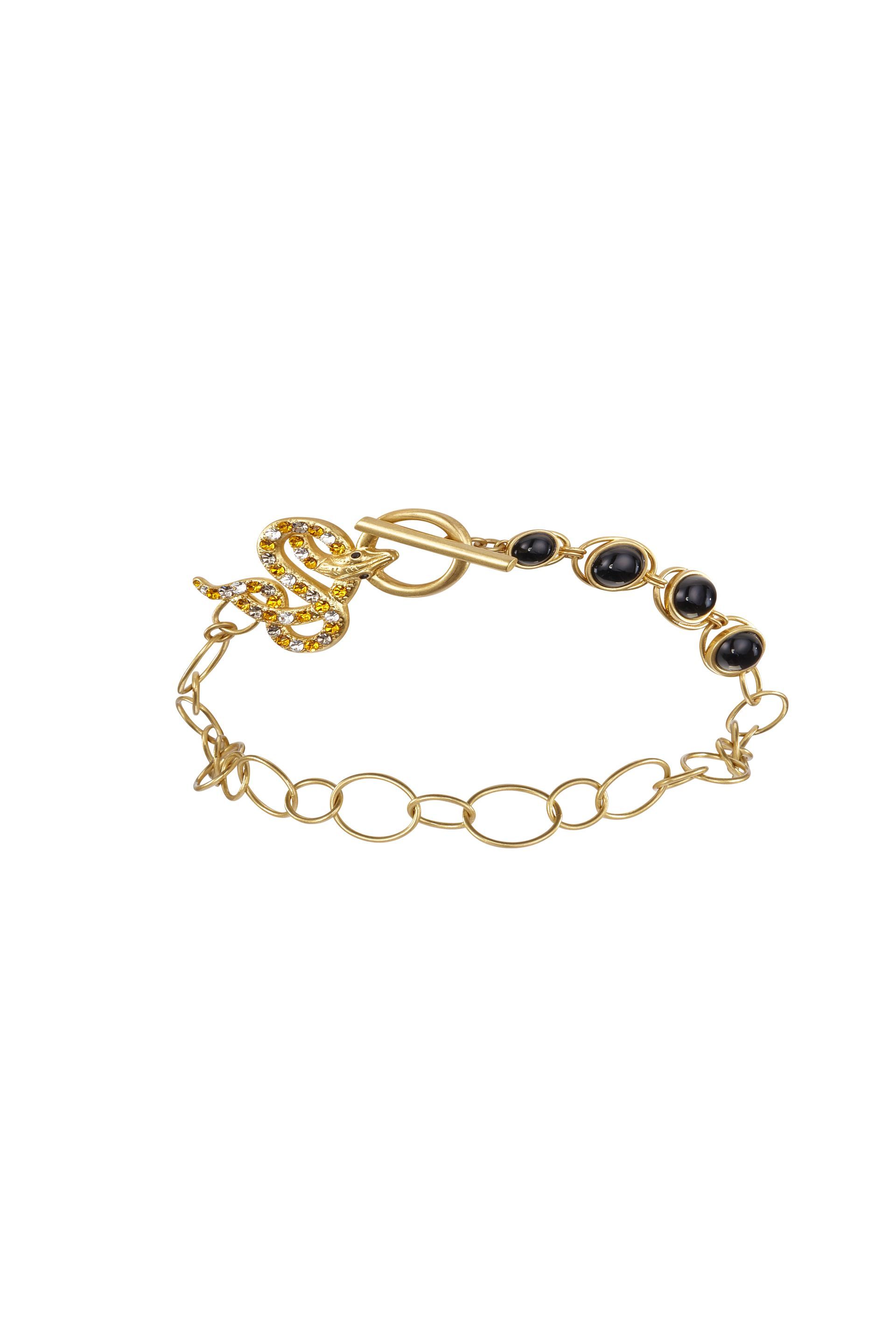A gold bracelet with black beads on a white background