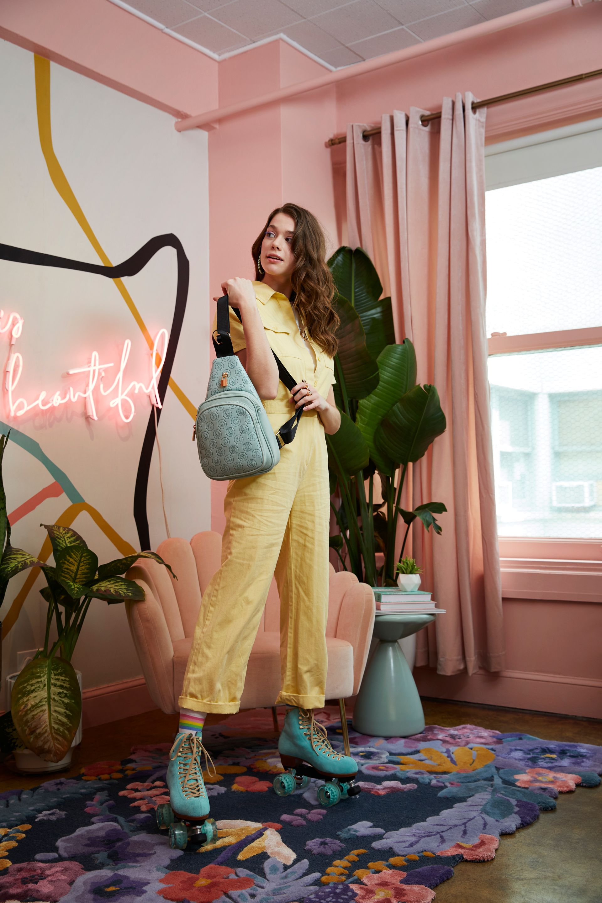 A woman is standing in a room wearing roller skates and holding a bag.