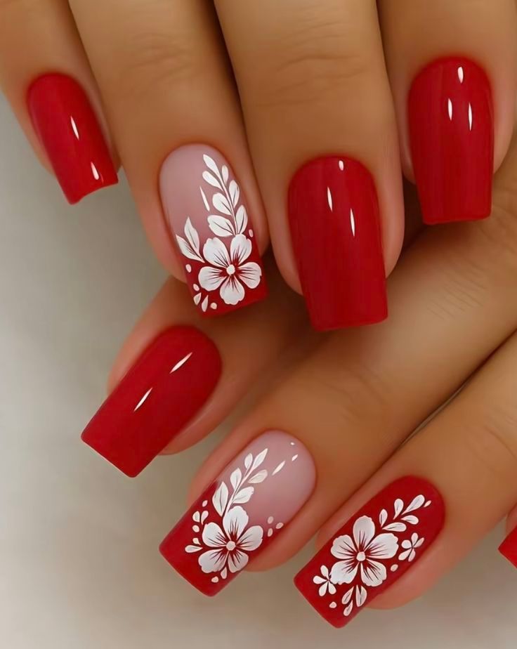 Red and white floral nail art on long, square-shaped nails.