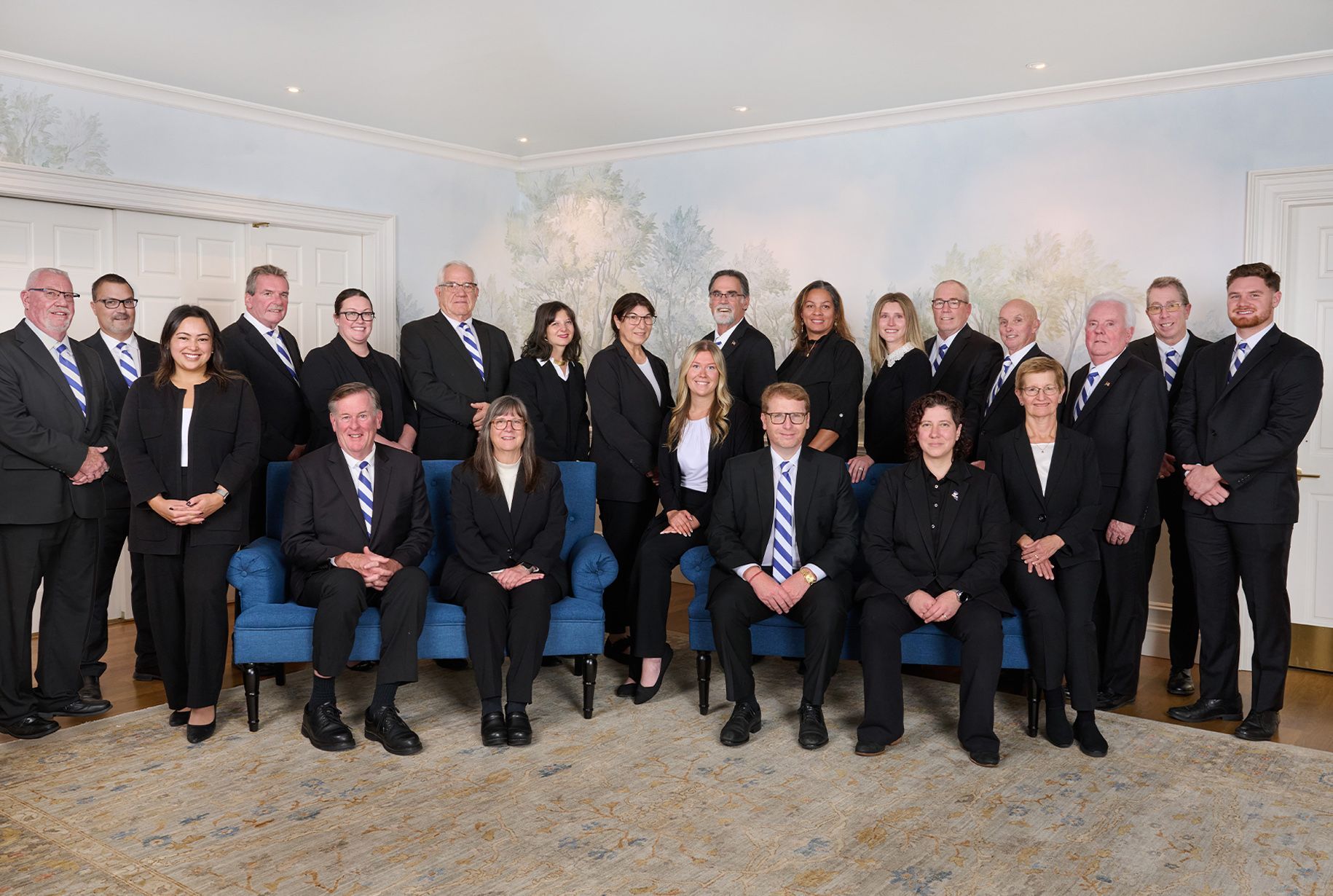 O'Donnell team posing in business attire indoors for a group photo.