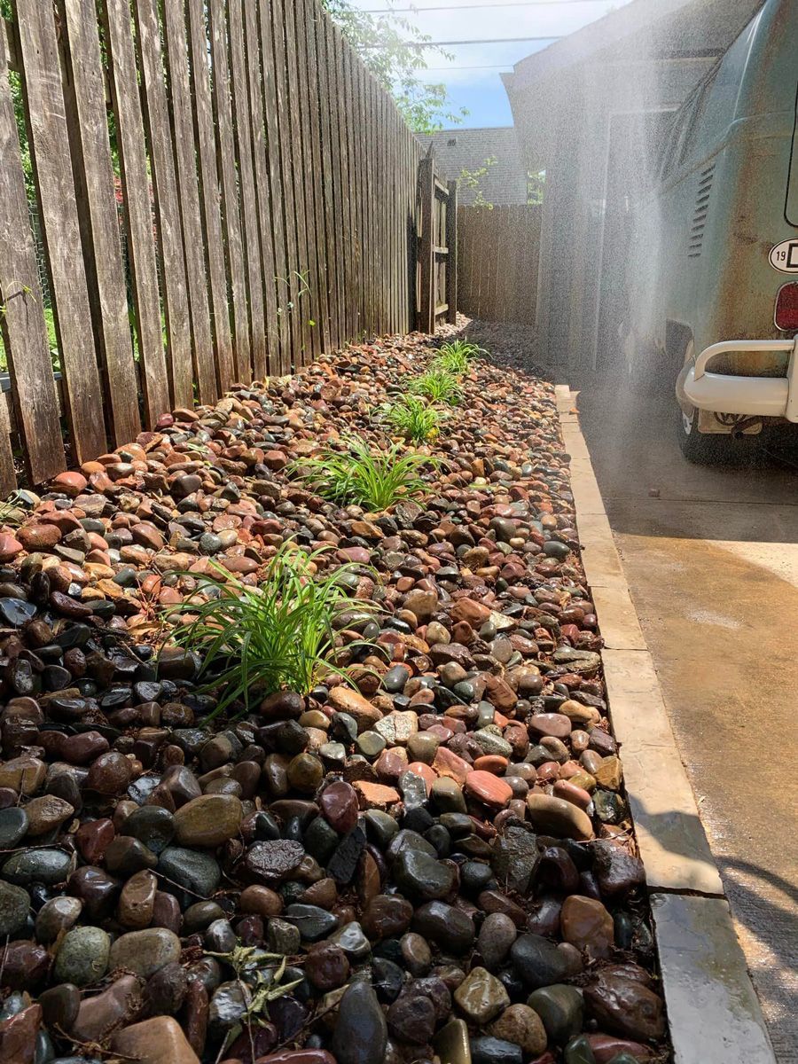 Pile of Rocks and Grass Next to a Wooden Fence — Saint Louis, MO — Zerr Lawn Care & Landscape LLC
