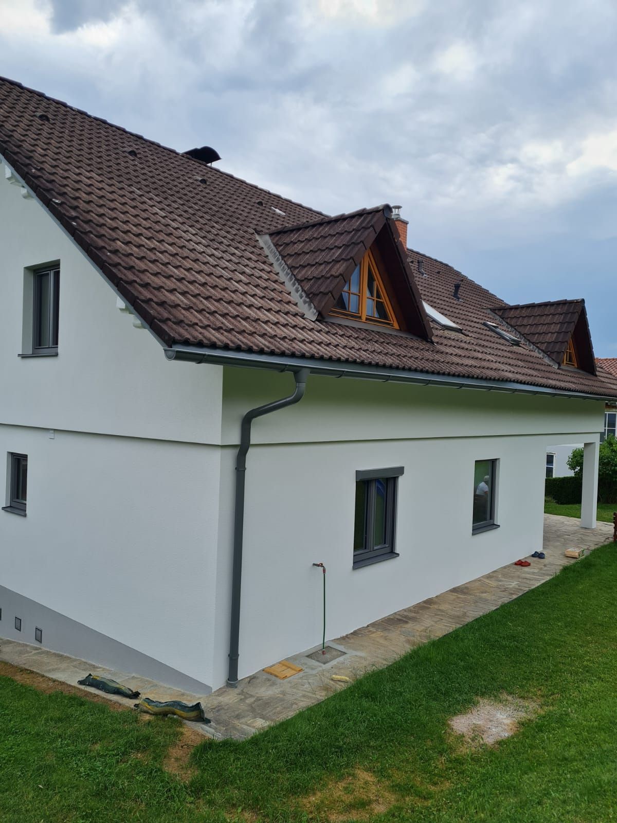 Ein weißes Haus mit einem braunen Dach und vielen Fenstern