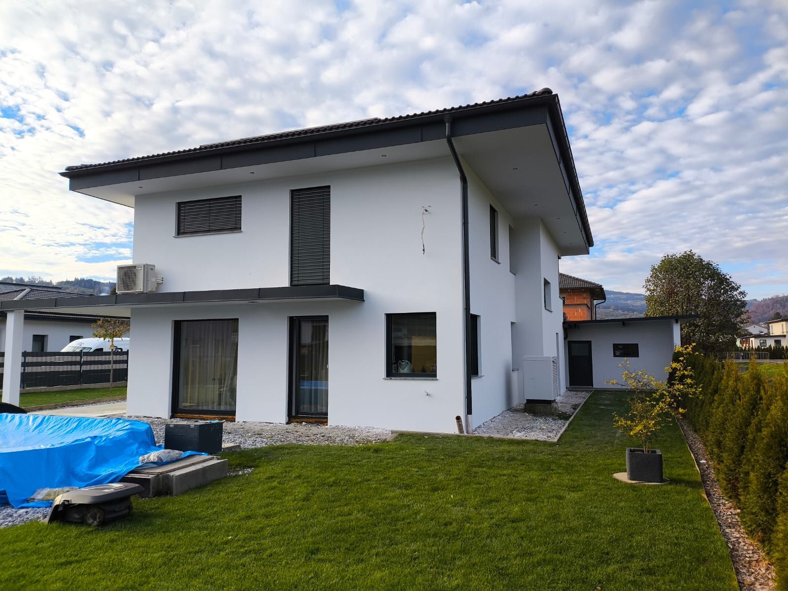 Ein weißes Haus mit einem Swimmingpool im Hinterhof.