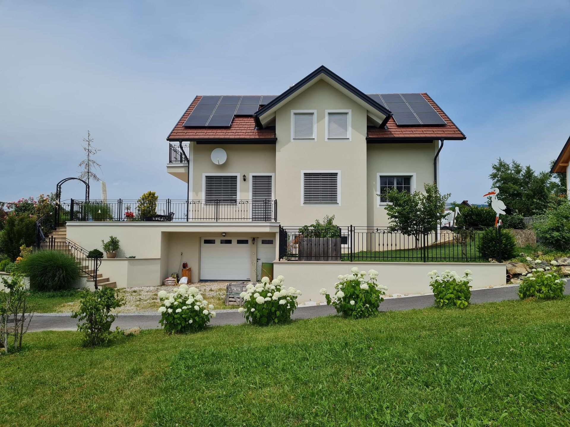 Ein großes weißes Haus mit Sonnenkollektoren auf dem Dach