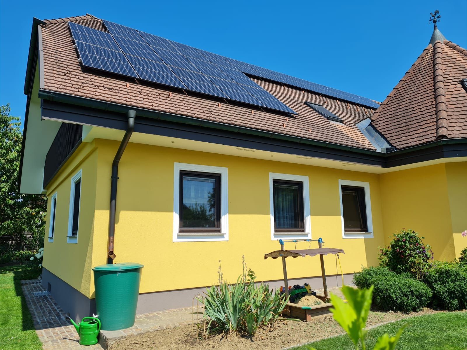 Ein gelbes Haus mit Sonnenkollektoren auf dem Dach