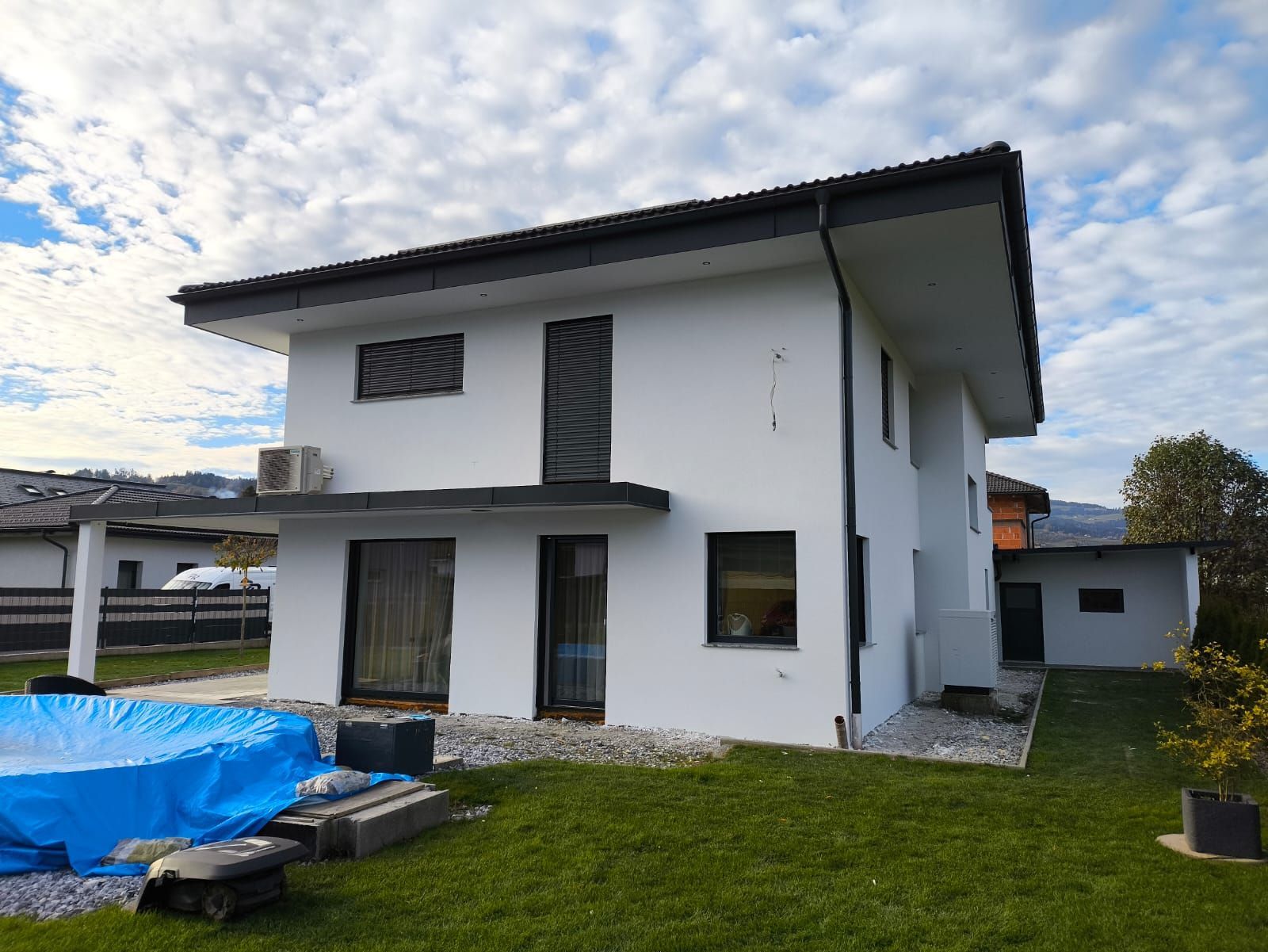 Ein weißes Haus mit einem Pool im Hinterhof.