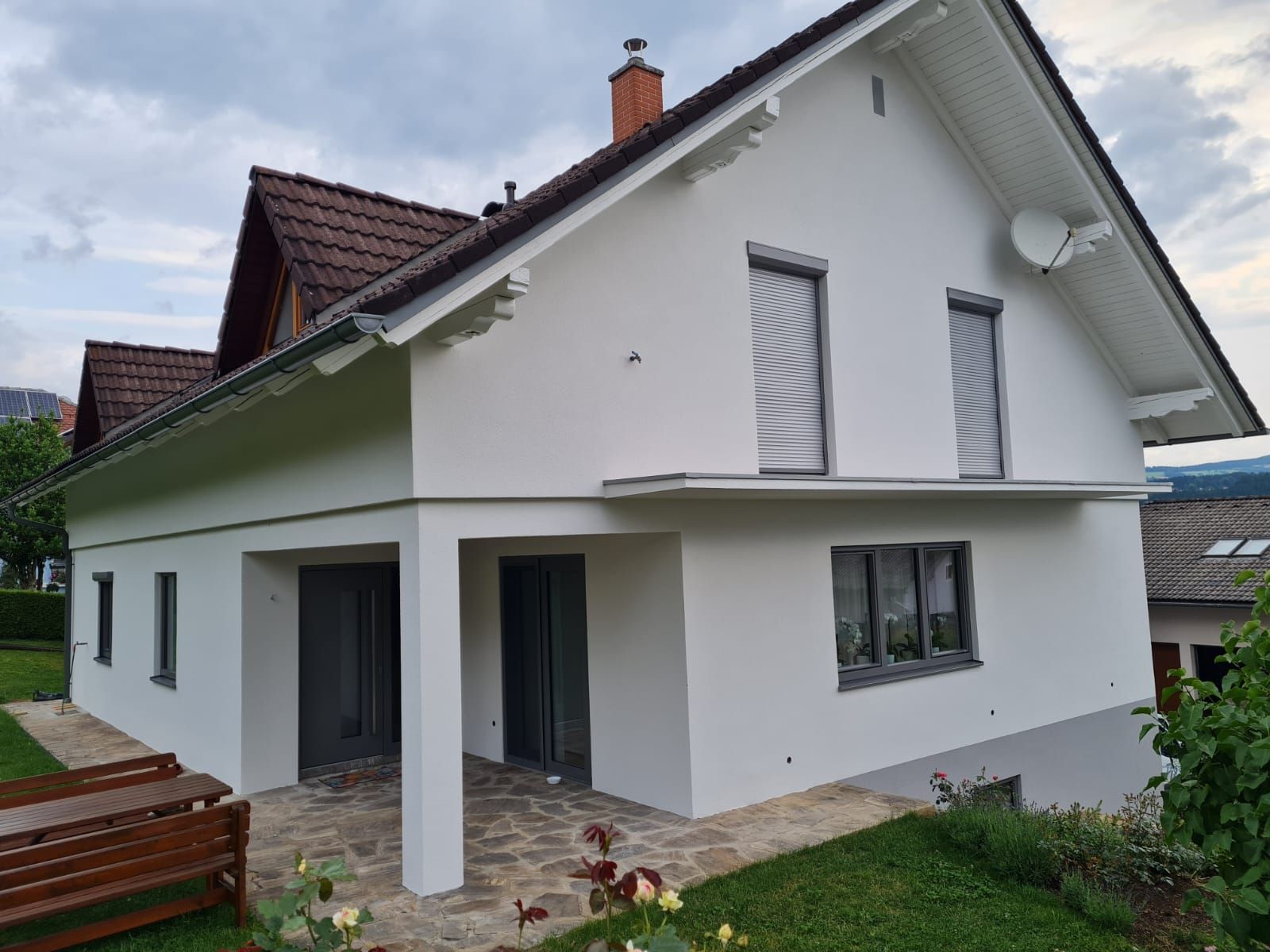 Ein weißes Haus mit einem braunen Dach und vielen Fenstern