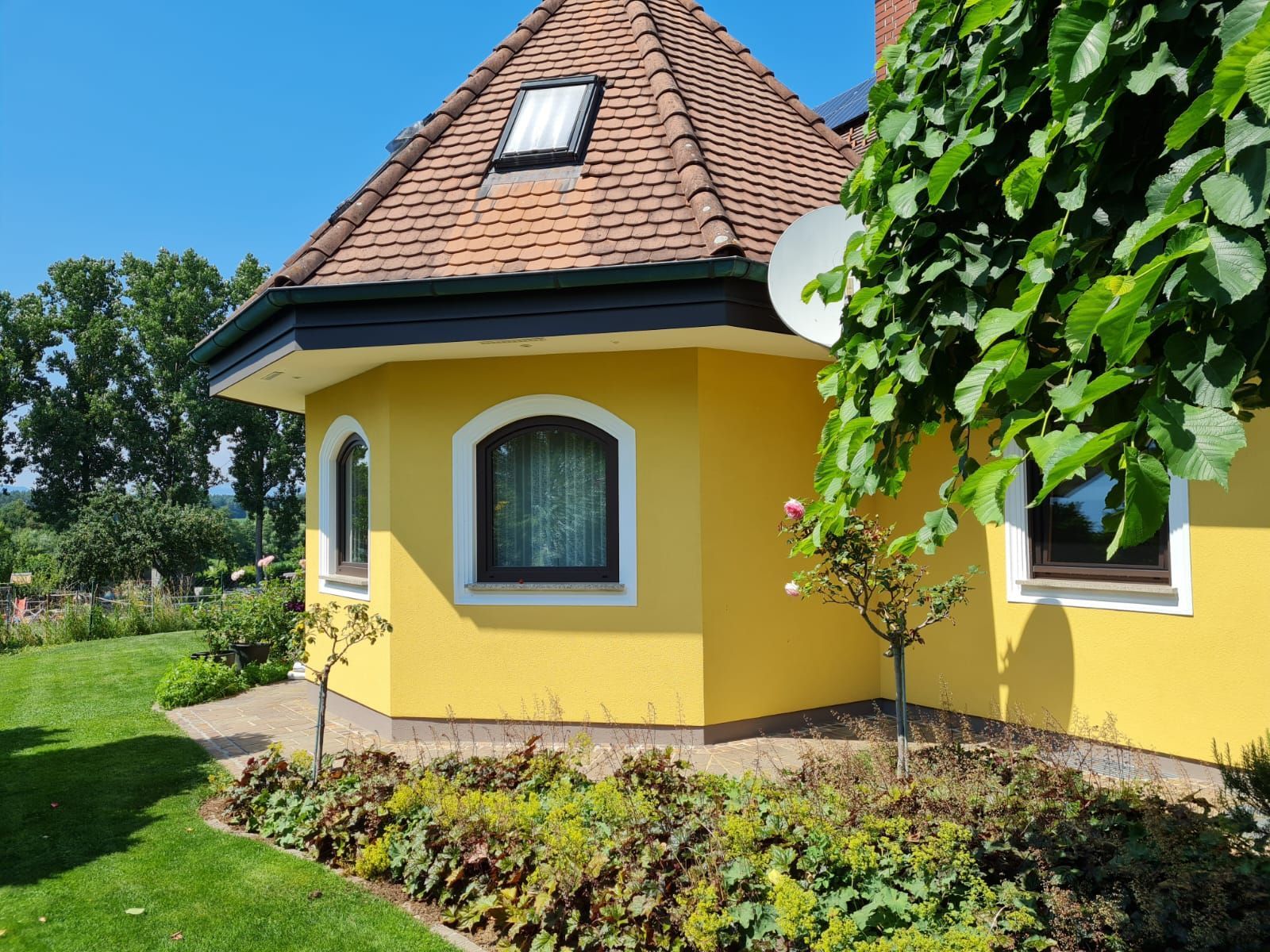 Ein gelbes Haus mit einer Satellitenschüssel auf dem Dach