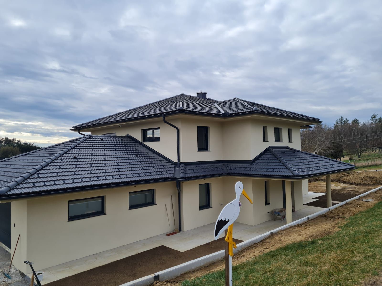 Es wird ein großes weißes Haus mit schwarzem Dach gebaut.