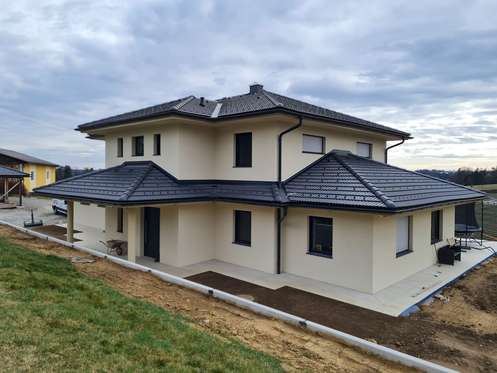 ein weißes Haus mit schwarzem Dach.