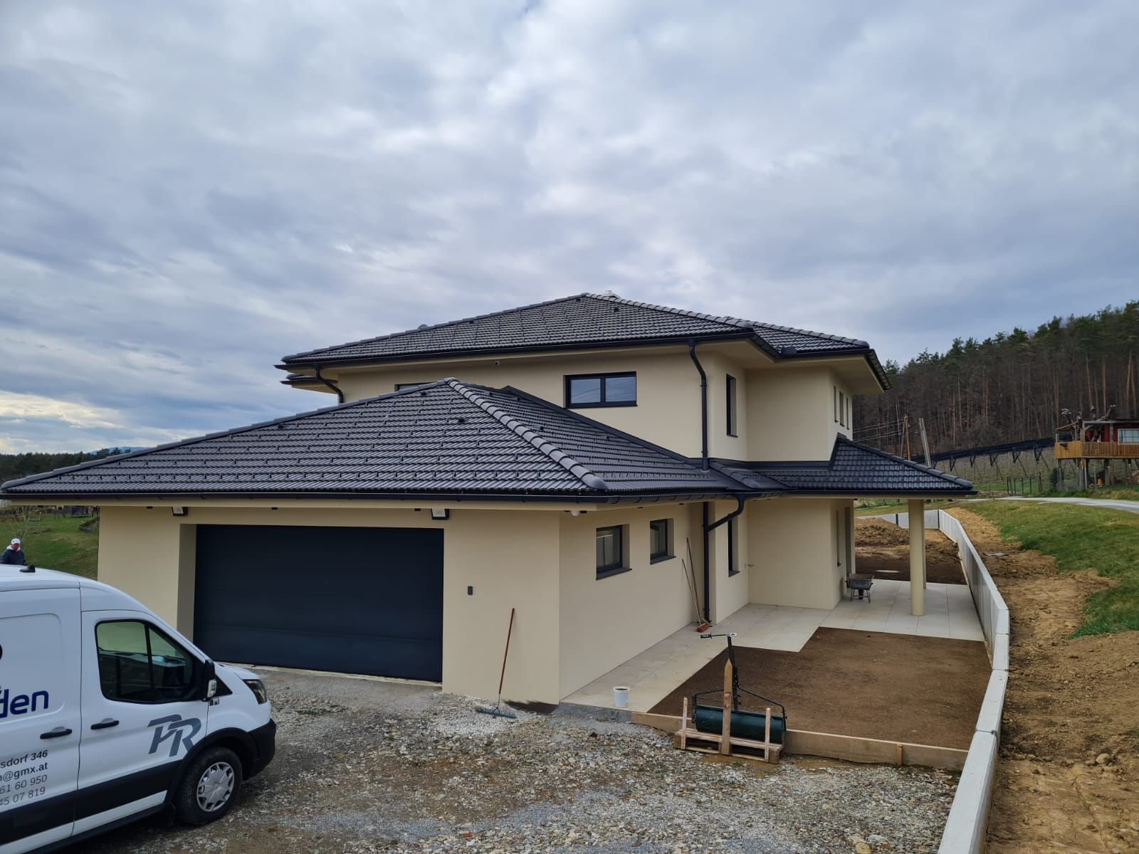 Ein neugebautes beiges Haus mit schwarzem Dach