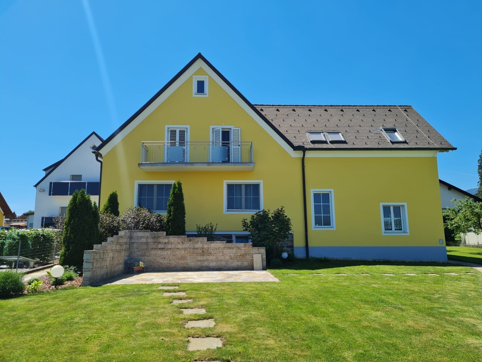 Ein gelbes Haus mit einem Dach, das ein Oberlicht hat