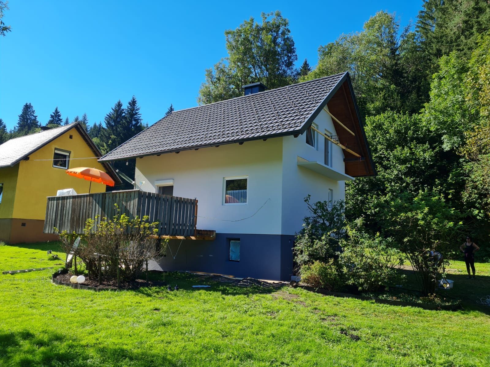 Ein Haus mit Balkon und Sonnenschirm davor