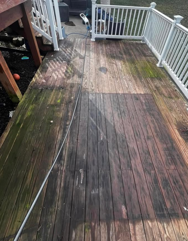 Weathered wooden deck with white railings and sunlit shadows along a narrow walkway