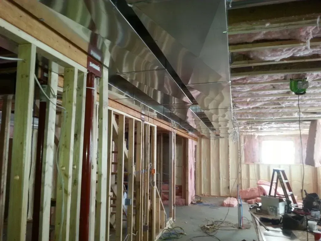 A building is being built with wooden beams and stainless steel pipes.