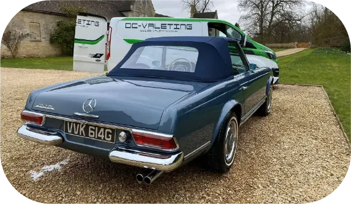 Blue classic Mercedes convertible on a gravel driveway. Two-tone paint, blue soft top, chrome details.